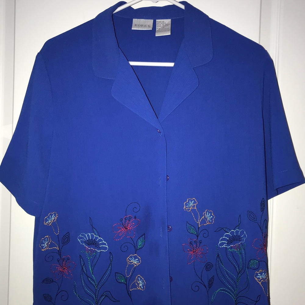 Blue button down shirt with a floral pattern.